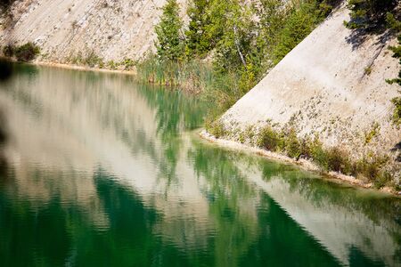 Deserted beach with clear turquoise rippled water on old lake formed on site of chalk quarry in Grodno Belarus in summer sunny day with copy space.の写真素材