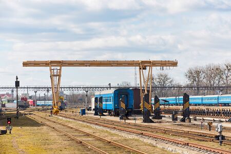 Railway gantry crane at point of uncoupled repair of locomotives railway carriages and trains at depot station Grodno or Hrodna Belarus at spring sunny day.の写真素材