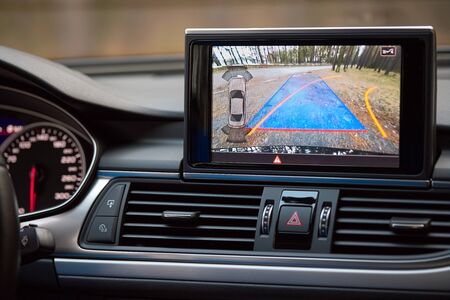 Interior of premium car with rearview camera dynamic trajectory turning lines and parking assistant steering wheel turned right. Driver assistance parking system. Help assist options of luxury car.の写真素材