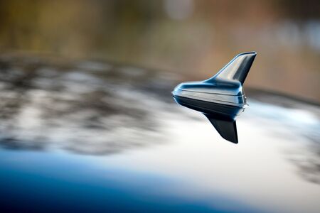 GPS antenna shark fin shape on a roof of german car for radio navigation system. Outdoor car radio antenna with drops of water.の写真素材
