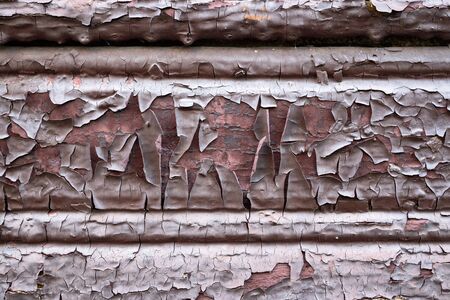 Old painted dilapidated flaky scaly wooden paint building wall brown chocolate colored pink inside as design background or texture for backdrop.の写真素材