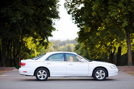 Crimea, Russia - September 20, 2015: Pearl white Mazda Millenia or Mazda Xedos 9 side view in park during test drive.のeditorial素材