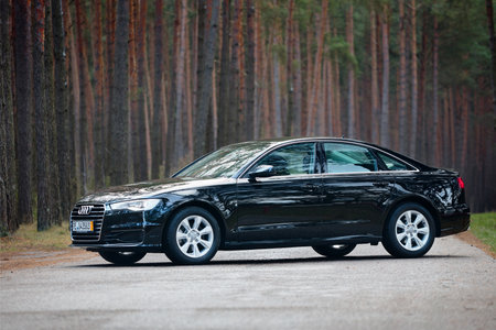 GRODNO, BELARUS - DECEMBER 2019: Audi A6 4G, C7 2.0 TDI 190 Hp 2016 facelift side view outdoors on winter road during testdrive with forest on background.のeditorial素材