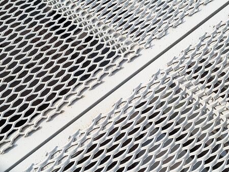 Perforated metal sheet stamping plates texture angled view. Made through metal stamping sheet metal manufacturing lightweight elements to loadbearing structural combine strength functionalityの写真素材