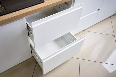 Part of the Contemporary Kitchen Interior - drawer for plates or dishes shelf under the sink with front panel made of woodの写真素材