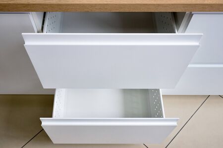 Part of the Contemporary Kitchen Interior - drawer for plates or dishes shelf under the sink with front panel made of wood top viewの写真素材