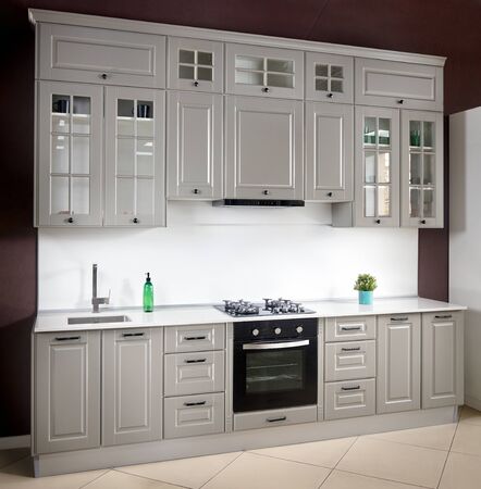 Interior of white and grey kitchen, horizontal. Luxury modern fitted flat design kitchen with glass elementsの写真素材