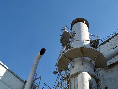 Bright air separation plant pipes and lanterns at bright sunny day over clear deep blue sky background with copy spaceの写真素材