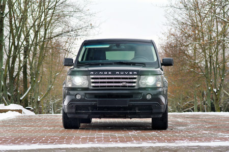 Grodno, Belarus, December 2012: Land Rover Range Rover Sport V8 Supercharged. Front view of black SUV, over out of focus winter forect background with copy space.のeditorial素材