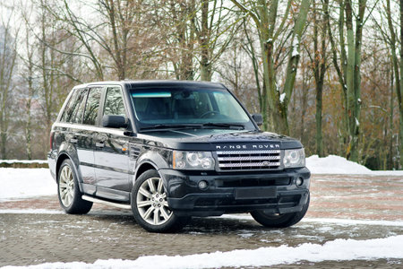 Grodno, Belarus, December 2012: Land Rover Range Rover Sport V8 Supercharged. Three fourth view of black SUV over out of focus winter park background, with copy space.のeditorial素材