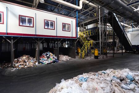 GRODNO, BELARUS - OCTOBER 2018: manual waste sorting department at modern waste plant with conveyor transports garbage inside drum filter sieve with trommel, for sorting garbage into fractions.の写真素材
