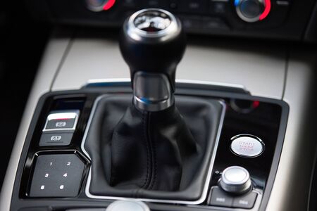 Engine start and stop button of modern and luxury car with aout of focus manual gearstick. Black interior. Keyless drive possibility, with the modern technology key.の写真素材