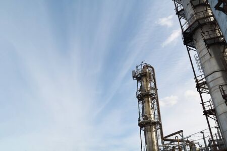Oil refinery chemical plant horizontal bottom view, with copy space over blue evening sky with clouds background.の写真素材