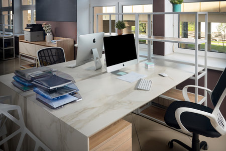 GRODNO, BELARUS - MAY 2020: Two Apple Imac in office table with stoneware table top, modern workplace of trendy office in loft style. Illustrative editorial.のeditorial素材