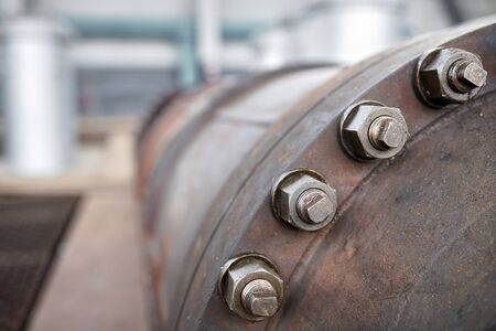 Bolted screw connection, sealing connection on manhole of industrial machine compressor or pump on chemical plant selective focus with out of focus abstract industrial background, with copyspace.の写真素材