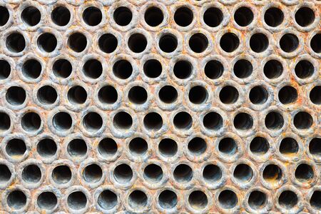 Tube sheet or plate of heat with welded tubes texture of stainless steel exchanger or boiler closeup texture vibrant colors background with insoluble hard mineral deposits salts scale and corrosion.の写真素材