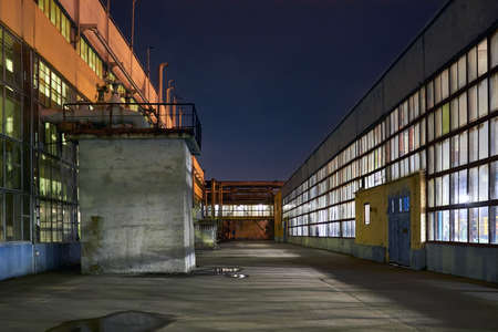 Night panorama of chemical plant building with dark blue sky. Compression buildings with jammer building and pipelines symmetry with copyspace.の写真素材