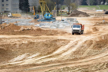 Multi-ton heavy mining dump truck loaded with cargo during removal of construction soil from construction site. Concept of providing transport shipping and freight for major construction projects.の写真素材
