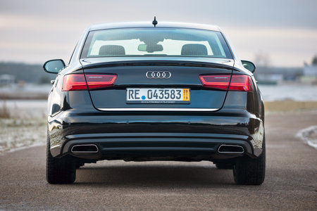 GRODNO, BELARUS - DECEMBER 2019: Audi A6 4G, C7 2.0 TDI 190 Hp 2016 black metallic rear view outdoors on winter empty road with lake on backgroundのeditorial素材