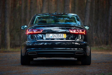 GRODNO, BELARUS - DECEMBER 2019: Audi A6 4G, C7 2.0 TDI 190 Hp 2016 black metallic rear view outdoors on winter empty road with dark forest on backgroundのeditorial素材