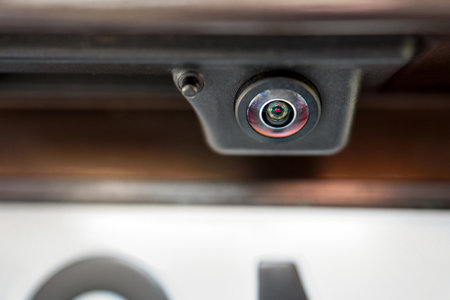 Luxury back car rear view camera close up, for parking assistance macro. Concept of safety car driving while parking process. Assist device equipment in modern cars in warm tones.の写真素材