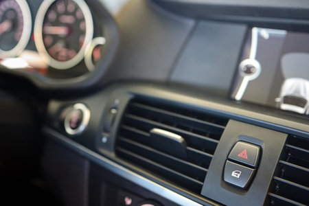 Selective focus of red warning triangle sign, emergency and door lock unlock button. Element of interior inside car with copy space.の写真素材