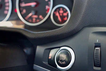 Selective focus on red enlightened Car Start Stop Engine Button. Element of interior inside car, with copy space.の写真素材