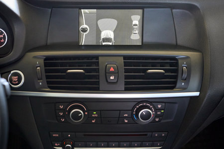 GRODNO, BELARUS - JUNE 2020: BMW X3 II F25 xDrive Premium car interior backup parking assistant system with sensors on screen with start stop engine and emergency buttons and climate control system.のeditorial素材