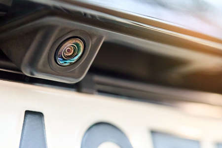 Luxury car rear view camera for parking assistance selective focus close up with sunflare and copyspace. Concept of safety car driving while parking process. Assist device equipment in modern cars.の写真素材