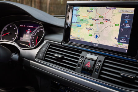 GRODNO, BELARUS - DECEMBER 2019: Audi A6 4G C7 interior in dark tones with display with GPS navigation map multimedia system climate control panels example of modern car technological equipment.のeditorial素材
