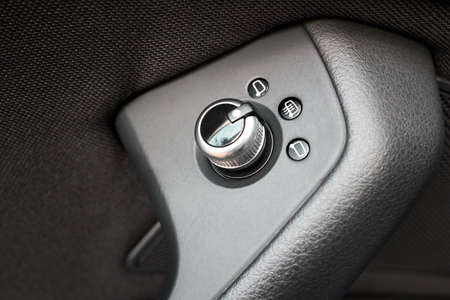 Luxury car interior Knob and buttons joystick for exterior electric mirrors control on driver door armrest for adjusting exterior mirrors by knob in desired direction and heating mirror glass button.の写真素材