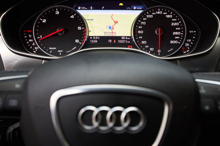GRODNO, BELARUS - DECEMBER 2019: Audi A6 4G C7 car dashboard display navigation GPS system with map radio fuel weather heat tachometer and speedometer with out of focus steering wheel with audi logoのeditorial素材