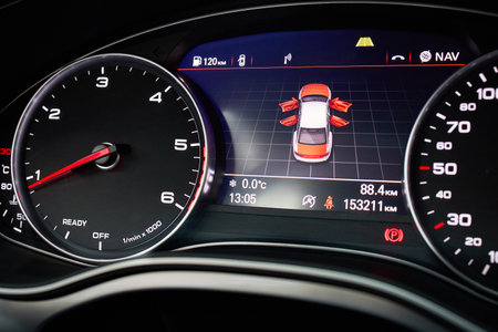 GRODNO, BELARUS - DECEMBER 2019: Audi A6 4G modern car electronic dashboard media display alert door open system warning icon on vehicle and radio fuel weather information tachometer and speedometer.のeditorial素材