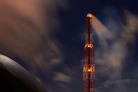 Signaled with red lights selective focus smoke pipe and spherical gasholder of petrochemical plant at night dark dramatic sky long time exposure shot with copyspace. Concept of environment pollution.の写真素材