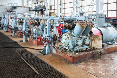 Interior element of chemical enterprise. Row of ammonia reciprocating compressors with cylinders and electric motor with control panel, with control devices and alarm systems.の写真素材