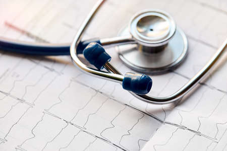 Medical healthcare concept. Selective focus cardiogram with out of focus stethoscope closeup macro background with copyspace and sunflare.の写真素材
