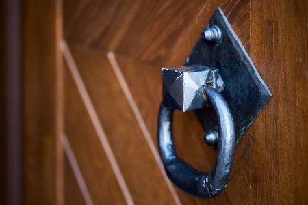 Door handle knocker selective focus on brown old wooden church entrance door side view with copyspace.の写真素材