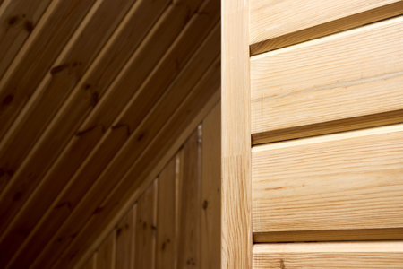 Interior carpentry background. Softwood clapboard, batten, plank timber blockhouse plank, or plank beam background with copyspace. Corner of rustic room finished with blockhouse or clapboard.の写真素材