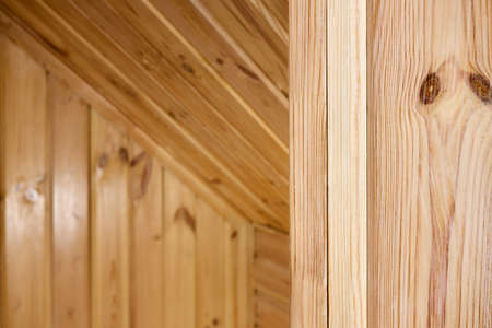 Interior carpentry closeup background. Softwood clapboard, batten, plank timber blockhouse plank, or plank beam background with copyspace. Corner of rustic room finished with blockhouse or clapboard.の写真素材
