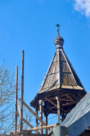 Wooden bell tower dome with orthodox cross of Church of the Beheading of St. John the Baptist in European city Grodno or Hrodna Belarus on blue sky background with cirrus clouds with copyspace.の写真素材