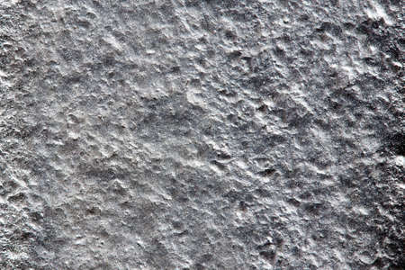 Closeup background of casting metal steel texture macro. Gray cast iron galvanized silver surface. Concept of lifeless desert surface of planet or asteroid.の写真素材