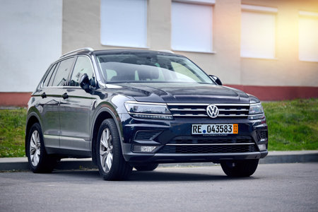 Berlin - May 2021:Outdoor photo of second generation Volkswagen Tiguan Allspace, 4x4 R-Line black compact crossover car SUV manufactured by Volkswagen parked in street with copyspace and sunflare.のeditorial素材