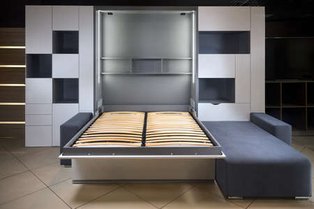Bedroom interior flat with Vertical Murphy Wall Bed, roll-away pull out bed stored into wardrobe with lots of shelves and drawers, minimalist interior design, modern architecture concept.の写真素材