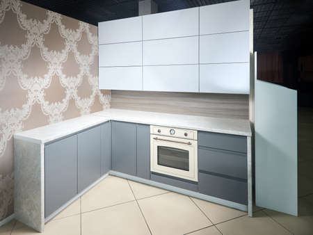 Interior of white and grey kitchen, horizontal. Luxury modern fitted flat design kitchen with glass elements and wallpaper.の写真素材