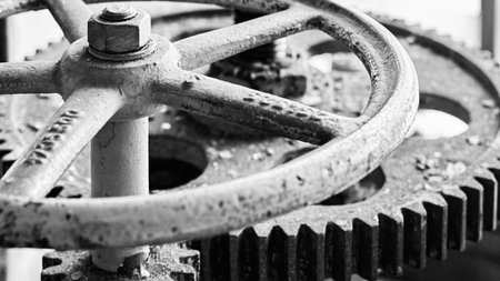 Old grunge steampunk valve wheel with gear gearbox selective focus with handle grip over out of...