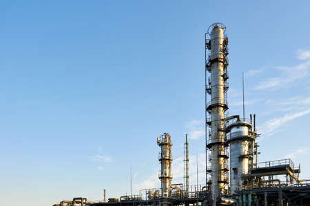 Oil refinery chemical plant wide view with copyspace over blue evening sky with clouds background. Methanol production distillation refinery columns industrial background with copyspace.の写真素材