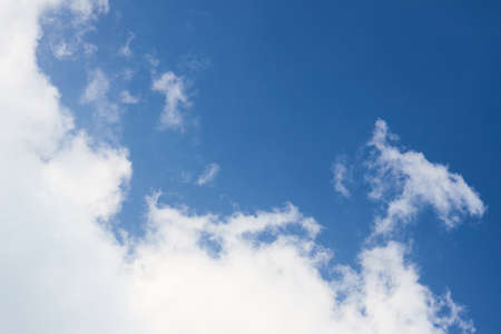 Cloud in the sky closeup over clear blue sky diagonal composition with copyspace.の写真素材