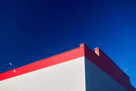 Aluminum composite panels for repair restore facade of commercial building white and red corner construction with led light flood outdoor wide angle with copyspace conceptual minimalism.の写真素材