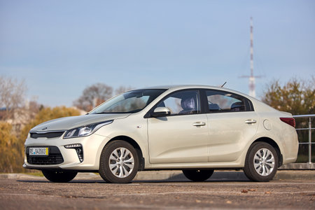 Berlin - October 2021: grey metallic sedan car 2017 Kia Rio IV Sedan YB fourth generation left side view at city parking urban background with copyspace.のeditorial素材