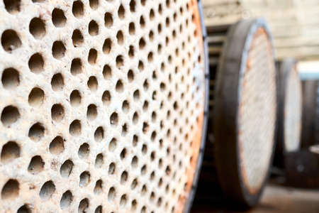 Corrosion, refinery heat exchanger chiller tubes with flange system. Row of Industrial heat exchanger or boiler rusty tube sheet or tube board with deposits and corrosion at petrochemical enterpriseの写真素材